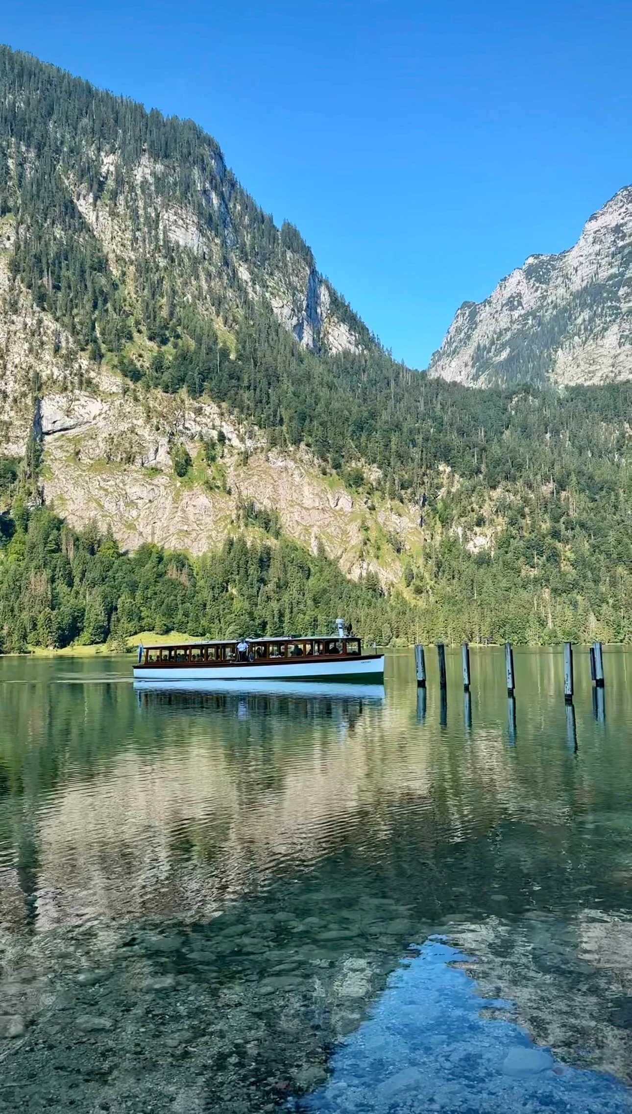 Königssee electric boat on the lake with steep mountain walls rising from the water