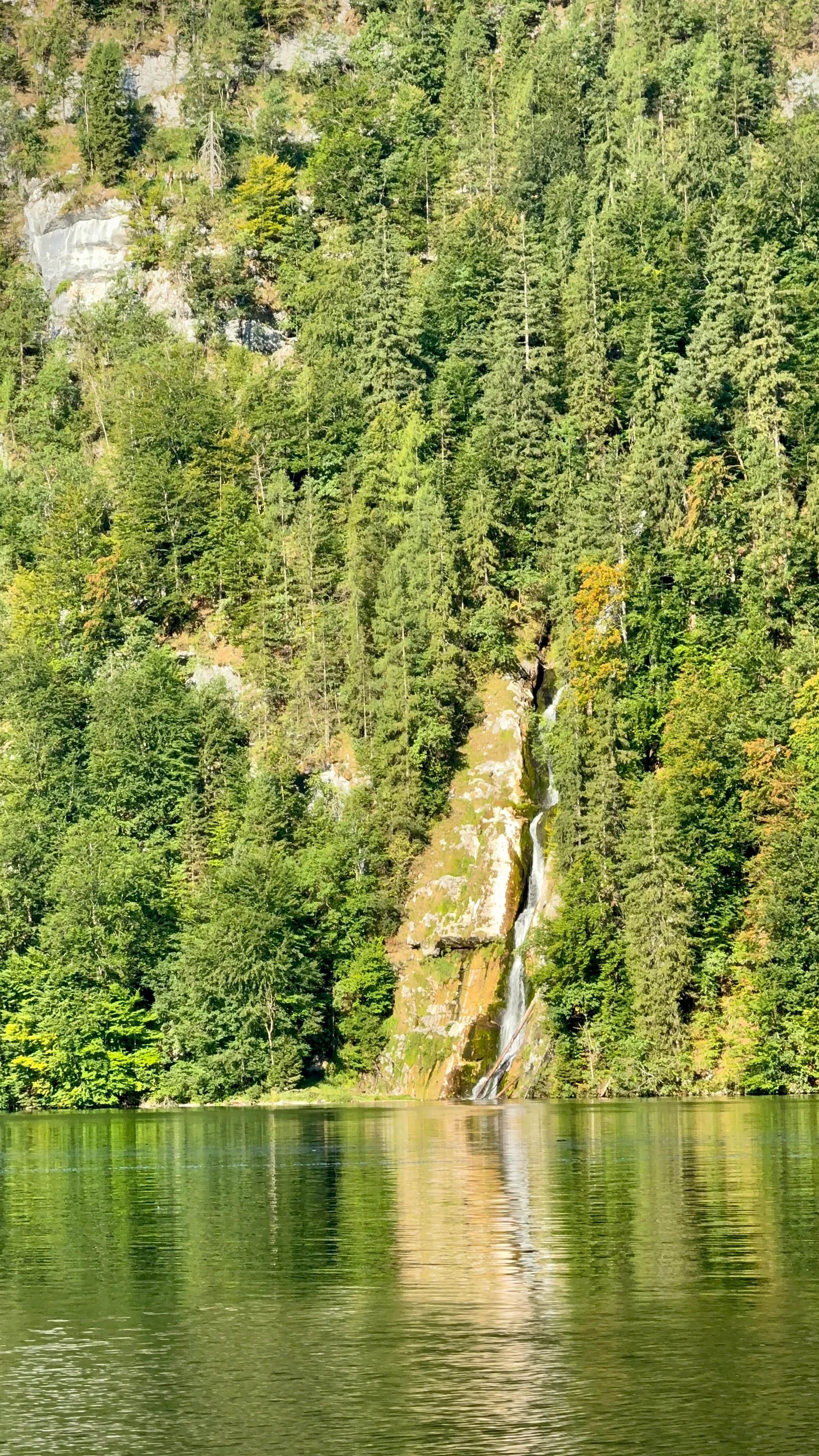 Electric passenger boat crossing Königssee with mountains rising from the shore